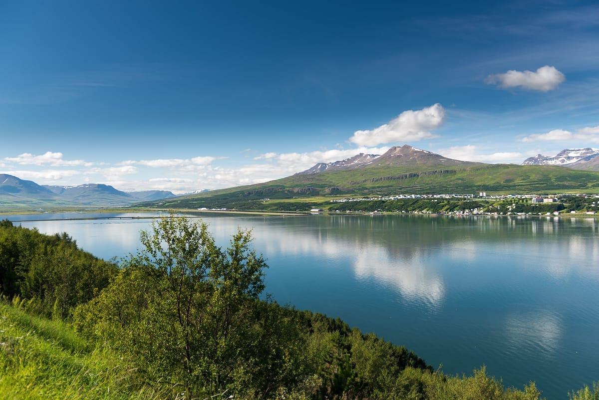 Akureyri am Ufer des Eyjafjörður mit hügeligem Zentrum, umrahmt von schneebedeckten Tafelbergen