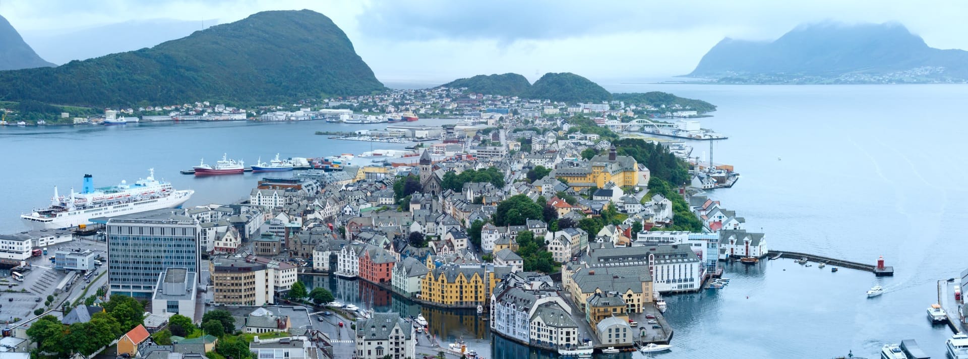 Panoramablick über die Hafenstadt Ålesund mit Kreuzfahrtschiff, aufgenommen vom Aussichtspunkt Aksla