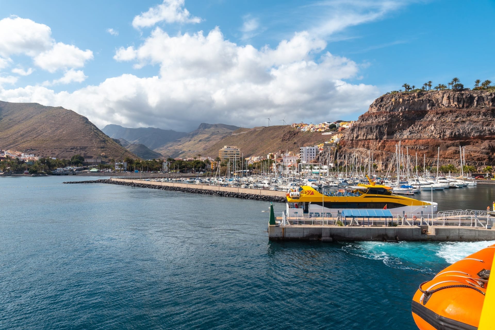Blick über den Hafen und die bunten Häuser von San Sebastián de La Gomera mit Bergen im Hintergrund