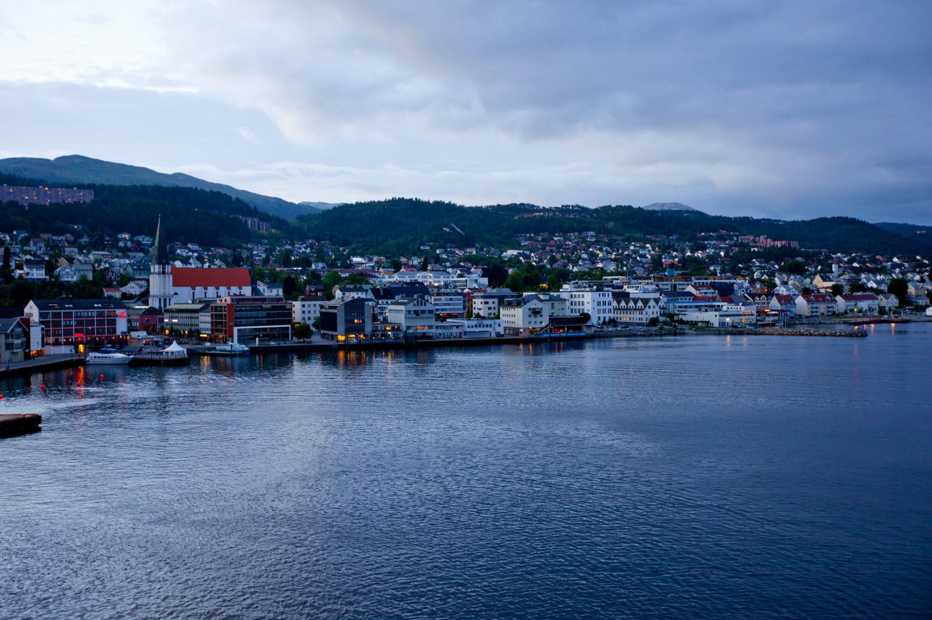 Blick über Molde mit Hafen und den schneebedeckten Gipfeln der Romsdalsalpen im Hintergrund