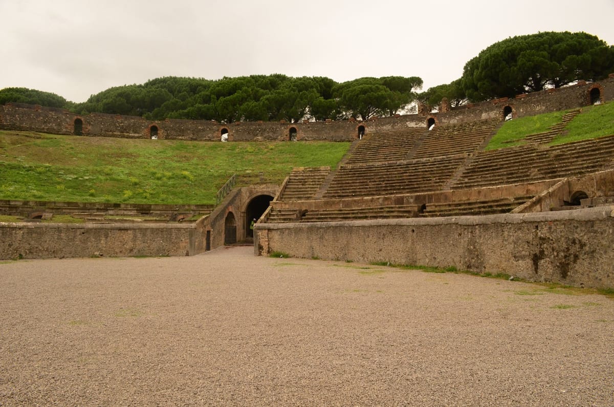 Das antike Amphitheater von Pompeji mit seinen Steinrängen und der begrünten Umfassungsmauer