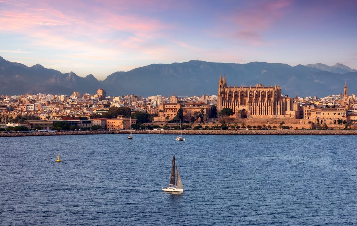 Blick vom Wasser auf die Altstadt von Palma mit Kathedrale La Seu und Almudaina-Palast im Abendlicht