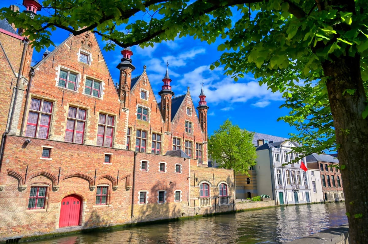 Historische Backsteinhäuser mit Staffelgiebeln und Türmchen an einer Gracht in Brügge