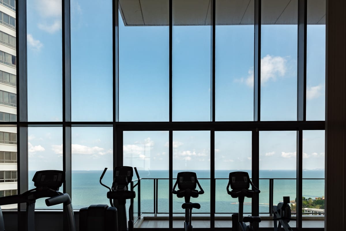 Fitnessstudio mit Laufbändern und Meerblick an Bord eines Kreuzfahrtschiffs