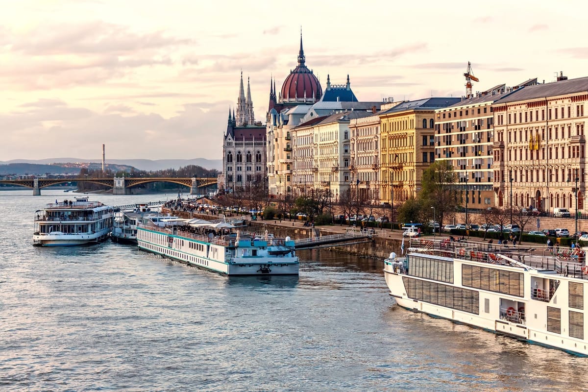 Flusskreuzfahrtschiff auf einem europäischen Fluss neben einer historischen Altstadt