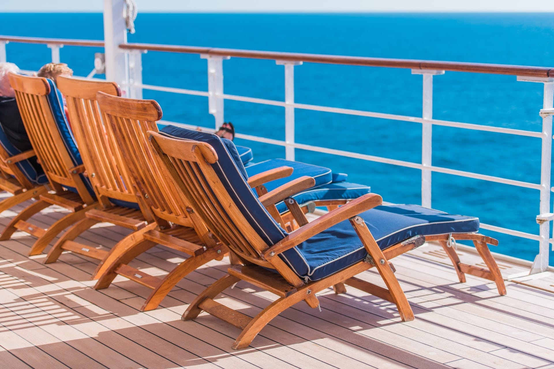 Liegestuhl am Pool eines Kreuzfahrtschiffs mit Blick auf das offene Meer